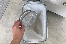 写真：排水口の毛をゴミ箱に捨てる